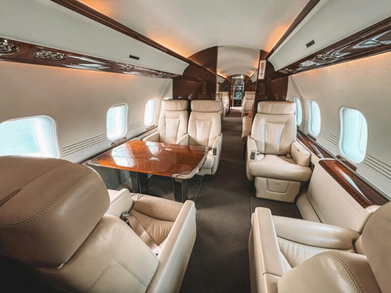 Luxurious interior of a private jet showcasing leather seating and elegant wooden trim, perfect for luxury travel - by Duchess Concept